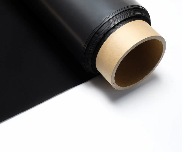 Musou Black Fineshut series ultra-black sheet unrolled from its core, showing the matte light-absorbing black material on a kraft paper tube